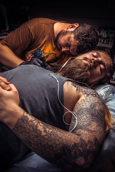 Professional tattoo artist at work in tatoo salon