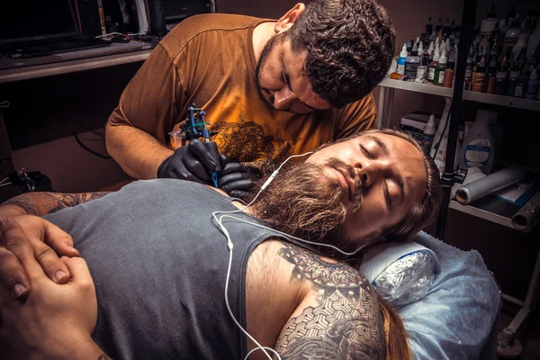 Professional tattooist makes cool tattoo in salon