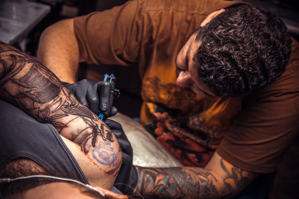 Tattoo artist working tattooing in tattoo studio