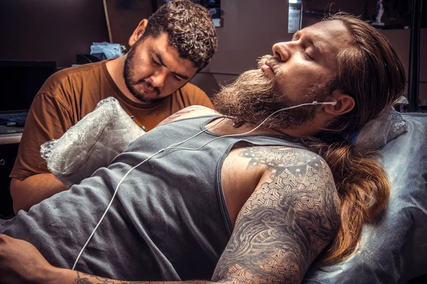 Master working tattooing in tattoo studio