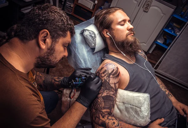 Tattoo artist makes tattoo in salon