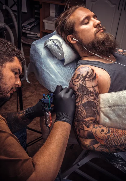 Tattoo artist works in tattoo studio
