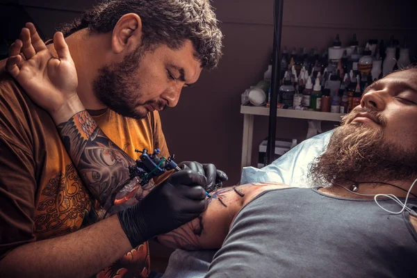 Master making a tattoo in tattoo studio