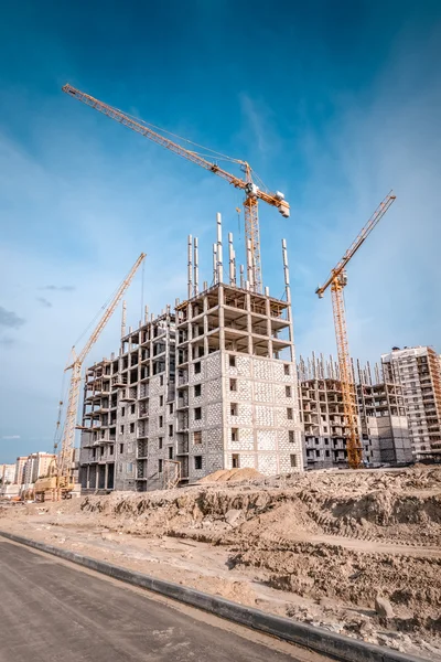 Tall buildings under construction with cranes