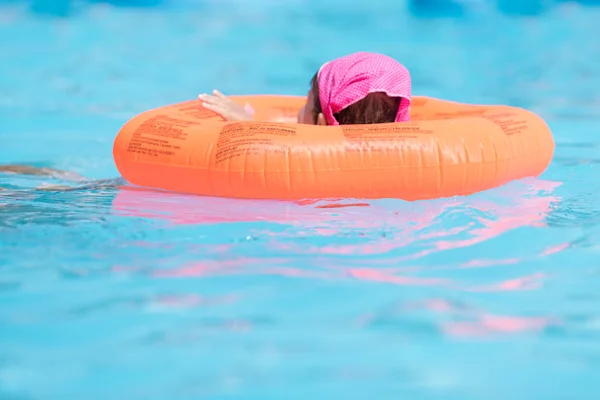 Child in swimming pool. Little girl with inflatable ring. Summer vacation concept