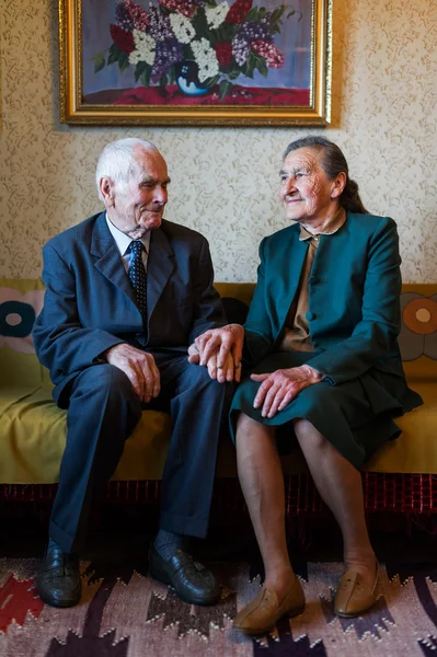 Cute 80 plus year old married couple posing for a portrait in their house. Love forever concept.