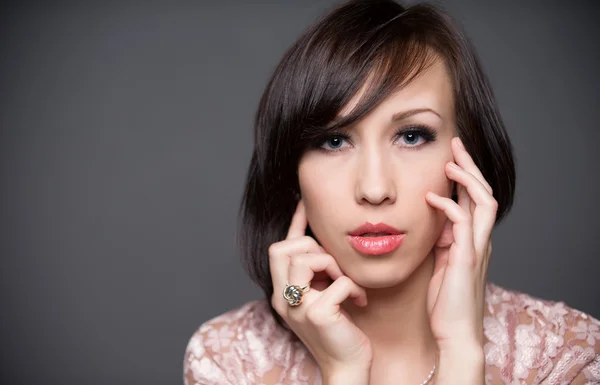 Horizontal colour image. beautiful young woman with healthy face and clean skin isolated on grey background