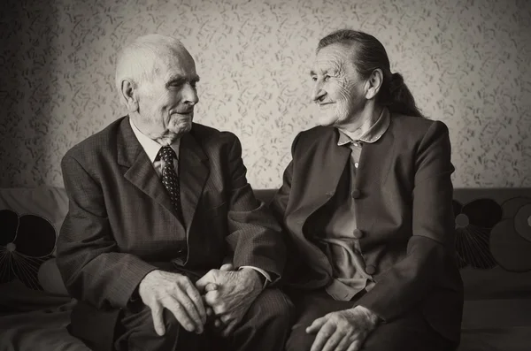 Cute 80 plus year old married couple posing for a portrait in their house. Love forever concept.