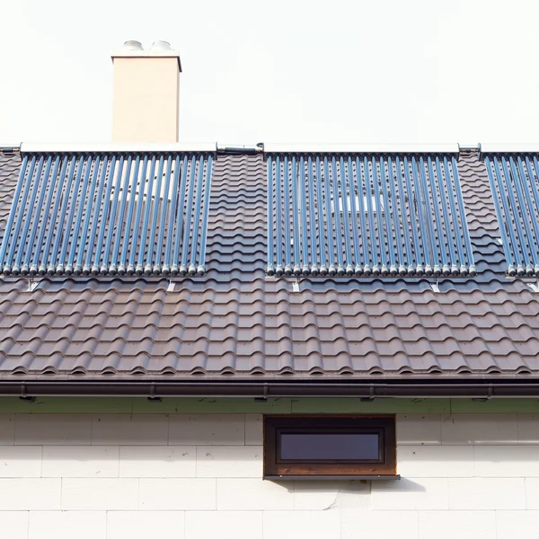 Vacuum solar water heating system on a house roof.