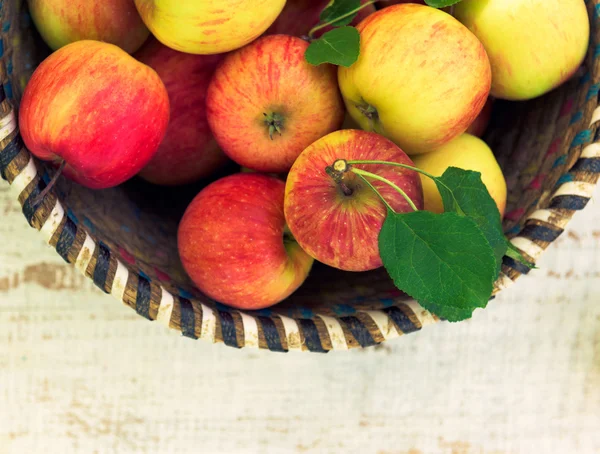 Organic apples in basket, on white vintage wooden background, fresh homegrown produce