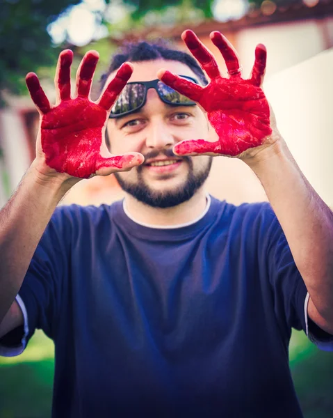 Man with hands painted with red body paint