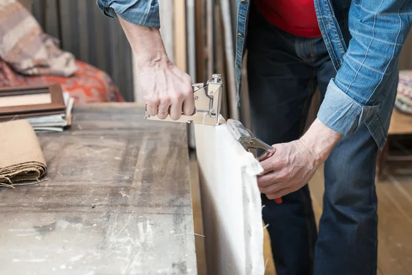 Closeup of an artists hands crafting canvas