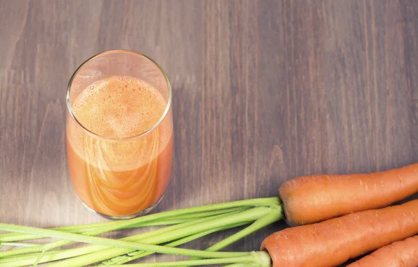 Healthy carrot smoothie in a glass and raw carrots