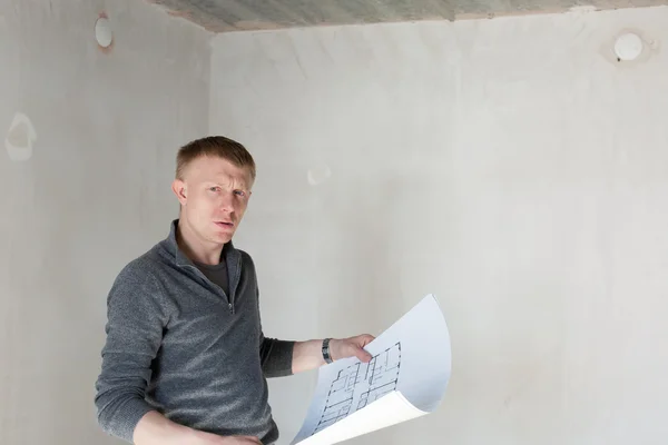An engineer examining blueprints on construction site