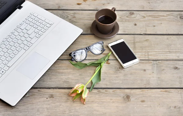 Laptop on wooden floor with coffee