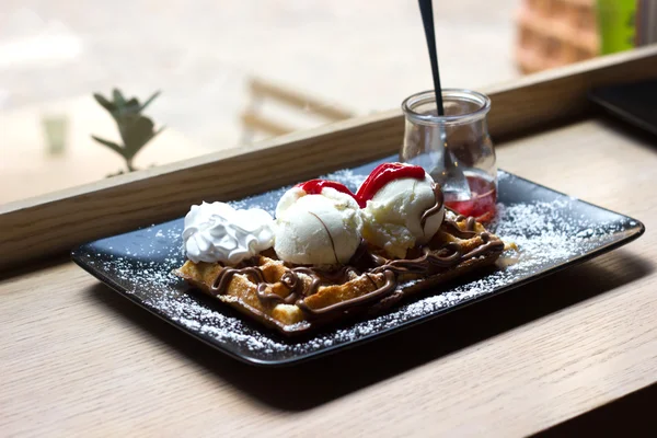 Belgian waffles with ice cream , chocolate, raspberry sauce and cream