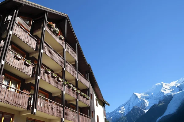 Ski resort vacation chalet hotel, European alps in distance, copy space