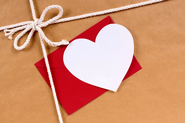 Valentine gift with white heart card, red envelope, brown paper