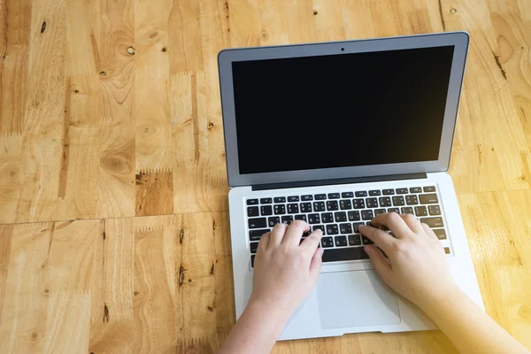 One person working with computer on wood table