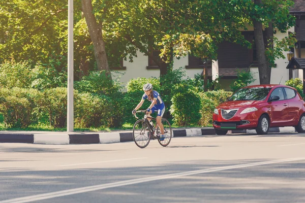 Female cyclist rides a racing bike on city road