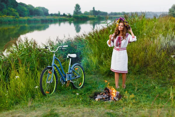 Young woman in national ukrainian folk costume with bicycle