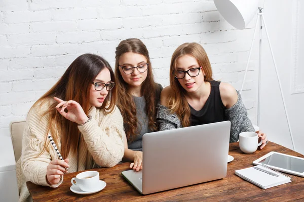 Three young women friends with laptop.