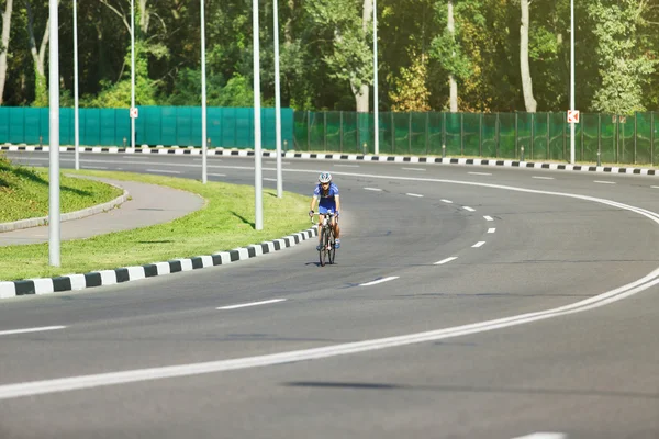 Female cyclist rides a racing bike on road