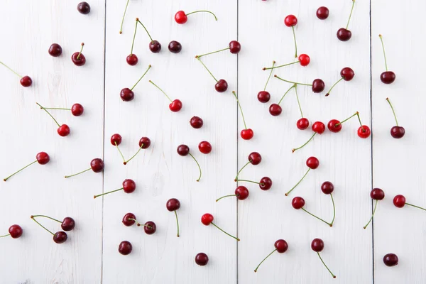 Sweet fresh cherries on white wood background