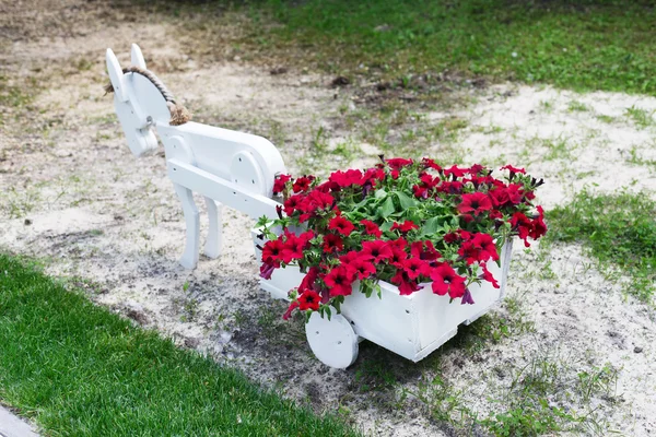 Flowerbed cart with bright pink flowers.