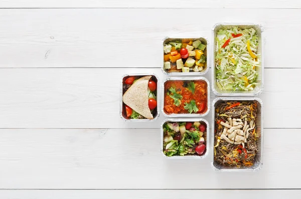 Healthy food take away in boxes, top view at wood