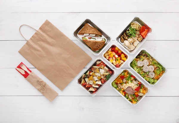 Healthy food take away in boxes, top view at wood