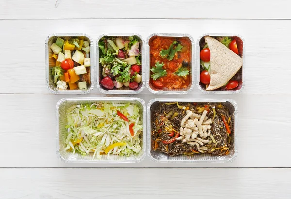 Healthy food take away in boxes, top view at wood