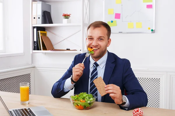 Man has healthy business lunch in modern office interior