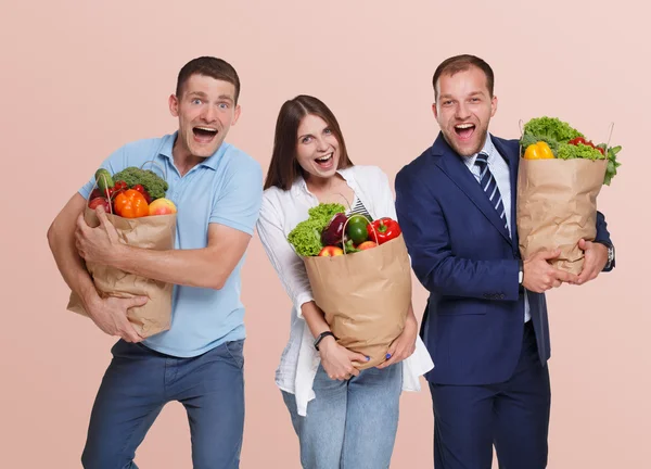 Happy people hold bags with healthy food, grocery buyers isolated