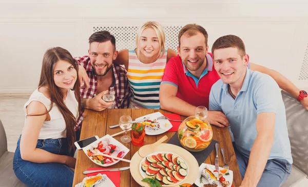 Group of happy young people at dinner table, friends party