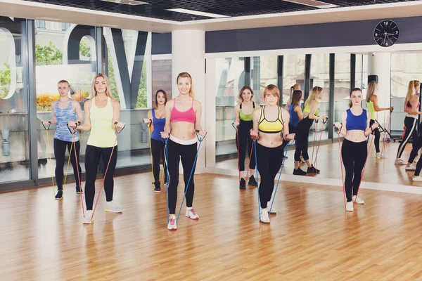 Group of women in fitness club with resistance band