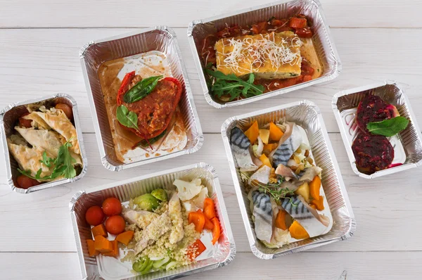 Healthy food take away in boxes, top view on wood