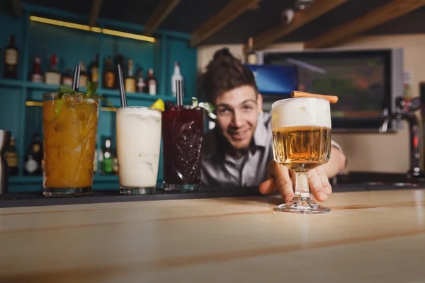 Young Barman offers non-alcoholic cocktails in night club bar
