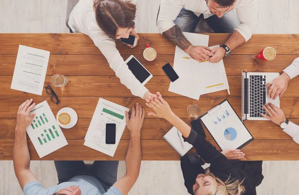 Business people group handshake in office, top view