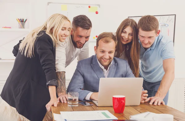 Happy business people team together near laptop in office