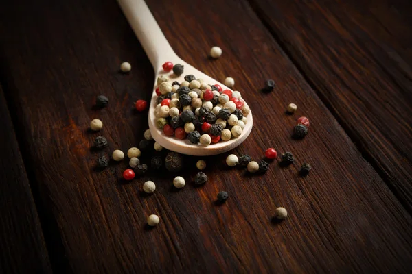 Mix of pepper seasoning in a wooden spoon