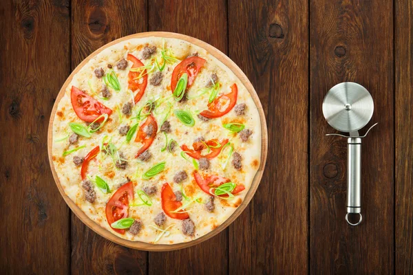 Delicious seafood pizza with tomatoes and cutter