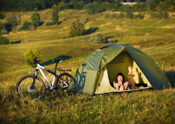 Travel with bicycle alone - young woman in the tent
