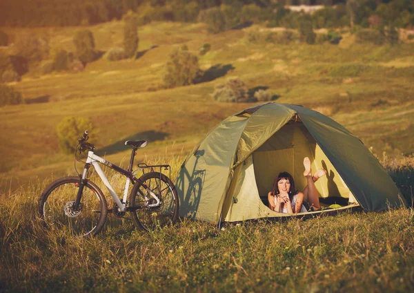 Travel with bicycle alone - young woman in the tent