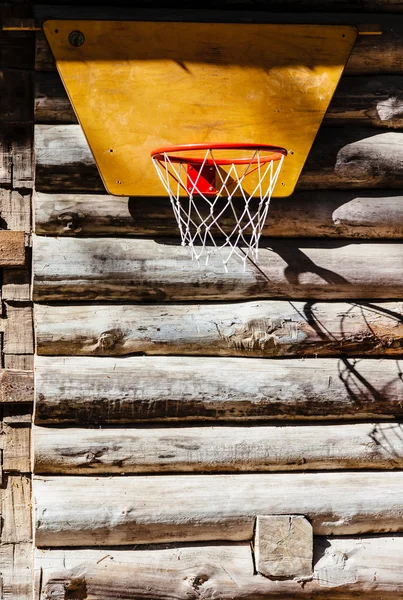 Basketball Hoop hanging on the wall of a wooden house