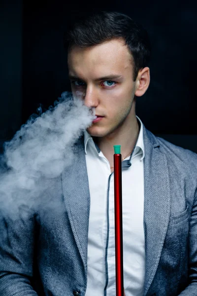 Man in blue suit smoking hookah