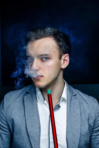 Man in blue suit smoking hookah