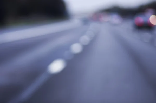 Abstract blurred car dangerous highway driving on wet rainy and foggy day. Rainy and foggy conditions on the highway. Motion blur visualizes the speed and dynamics.