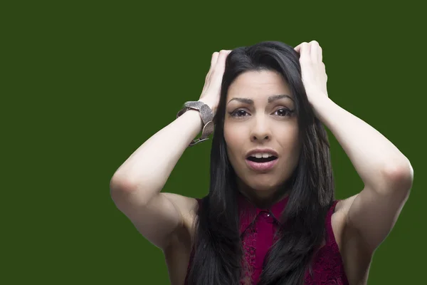 Young woman showing her fear towards someone over a green screen that can be replaced by any background.