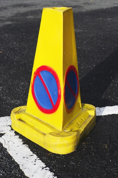 A yellow traffic cone with no parking